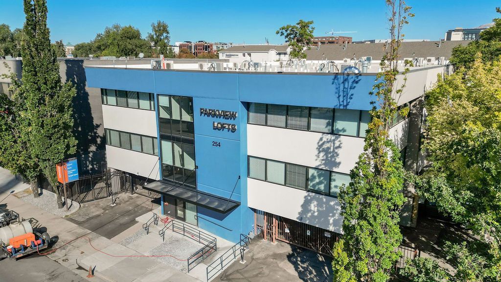 An aerial view of a large blue and white building surrounded by trees.