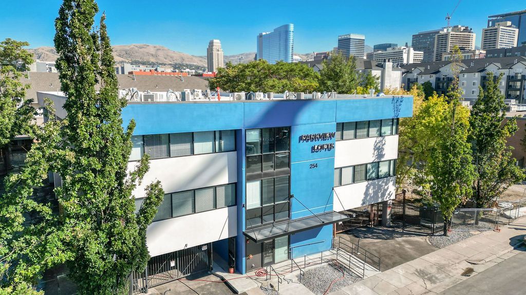 An aerial view of a blue and white building with trees in front of it.
