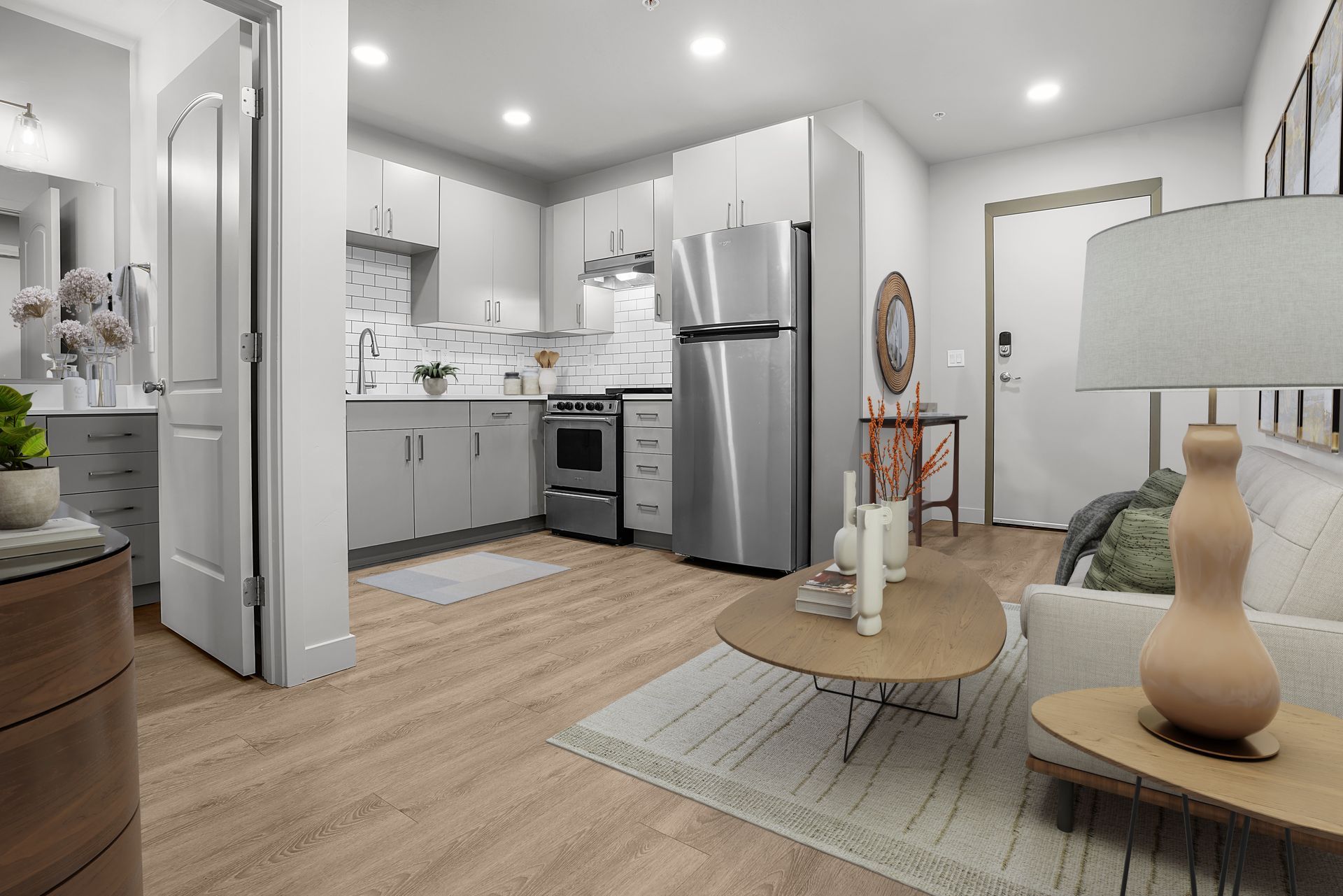 A living room with a couch , table , lamp , and refrigerator.