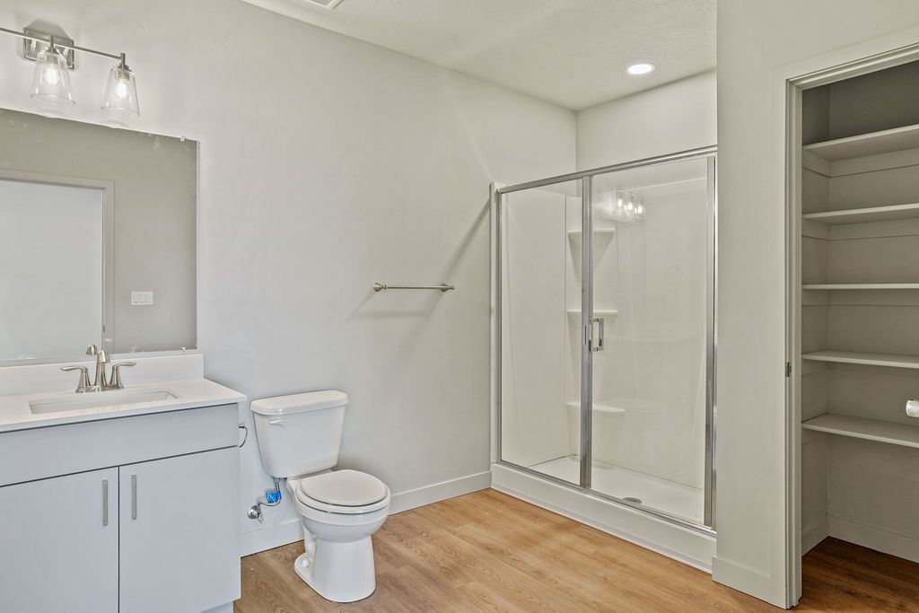 A bathroom with a toilet , sink , and walk in shower.