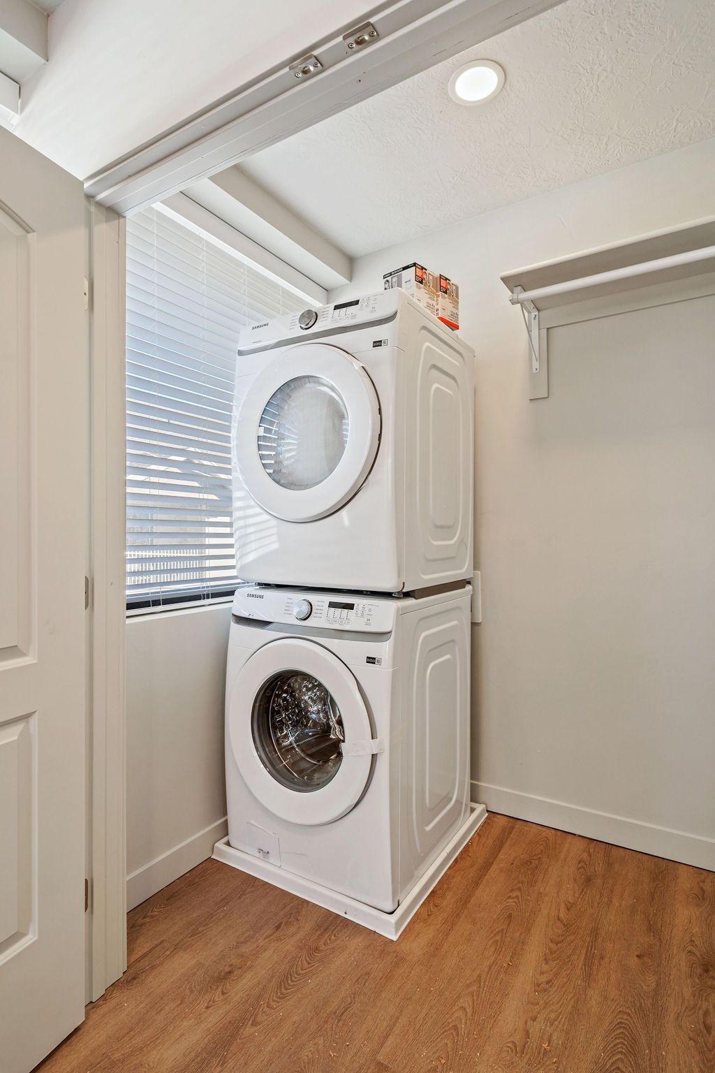 A washer and dryer are stacked on top of each other in a laundry room.