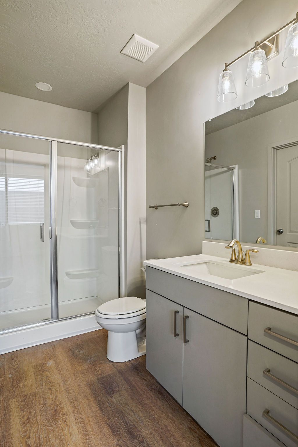 A bathroom with a toilet , sink , and shower.