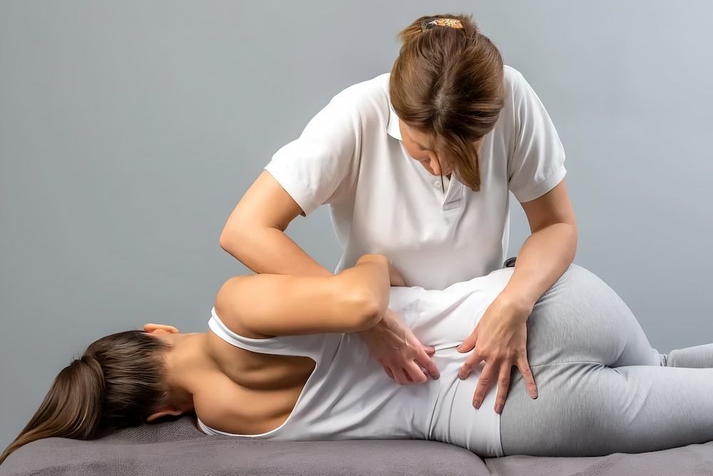 Woman Receiving Back Adjustment From a Healthcare Provider — Living Well Chiropractic Coffs Harbour in Coffs Harbour, NSW