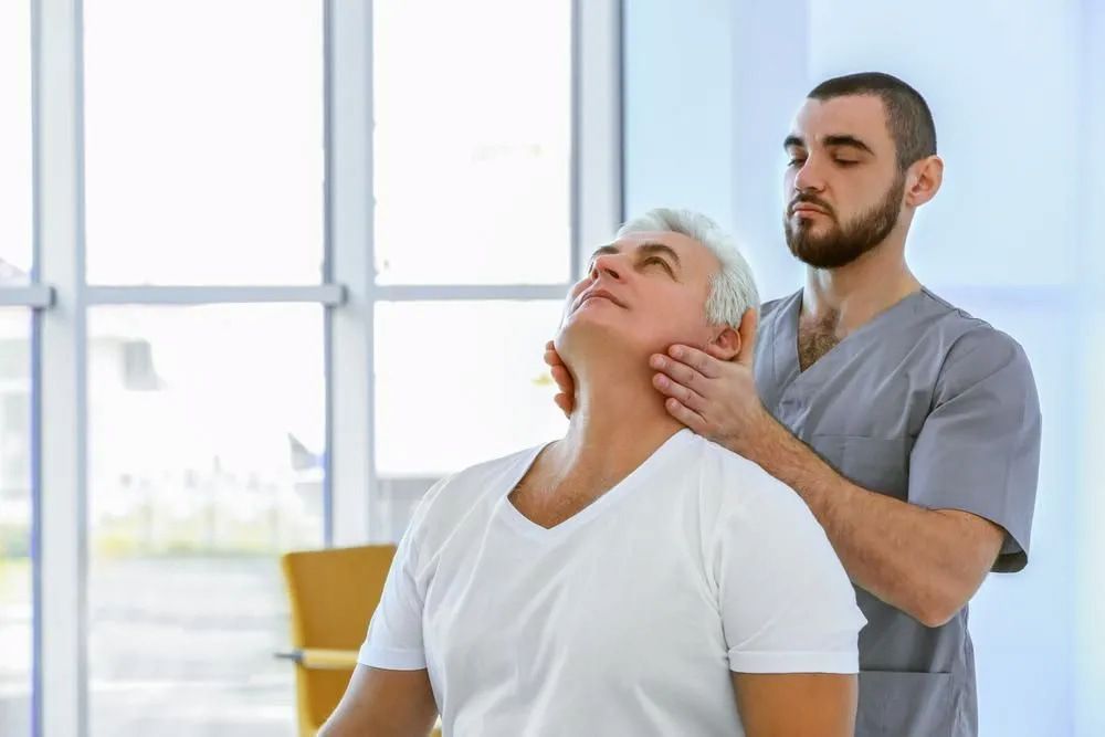 Examining a Neck — Living Well Chiropractic Coffs Harbour in Coffs Harbour, NSW