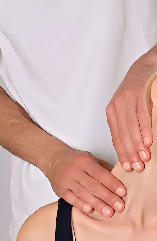 Hands Massaging a Person's Neck and Shoulder — Living Well Chiropractic Coffs Harbour in Coffs Harbour, NSW