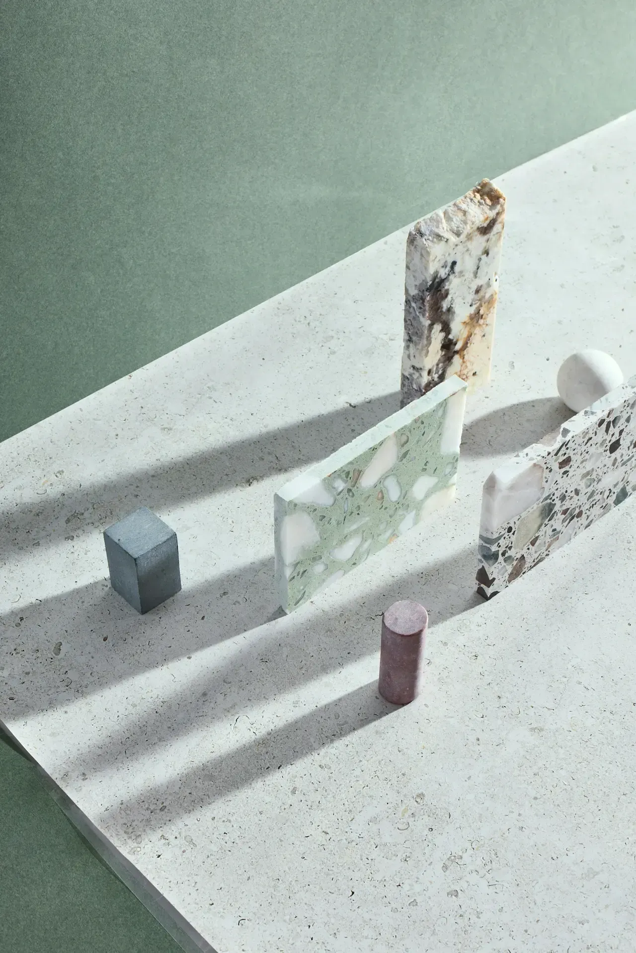 Abstract tabletop sculpture with geometric shapes, a tall stained panel, and soft shadows on a white surface