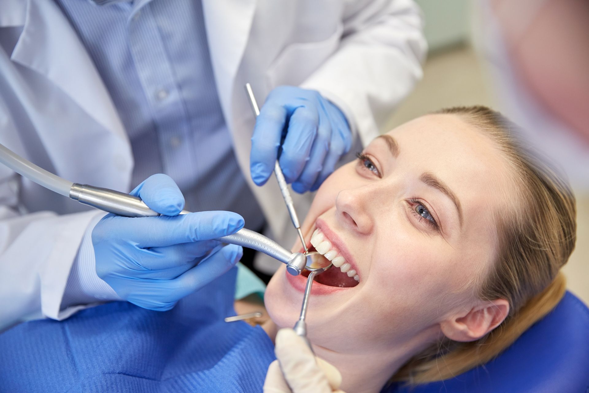 A woman is having her teeth examined by a dentist.