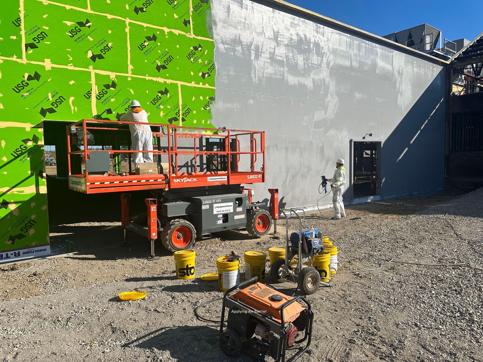 a group of construction workers are painting a building .