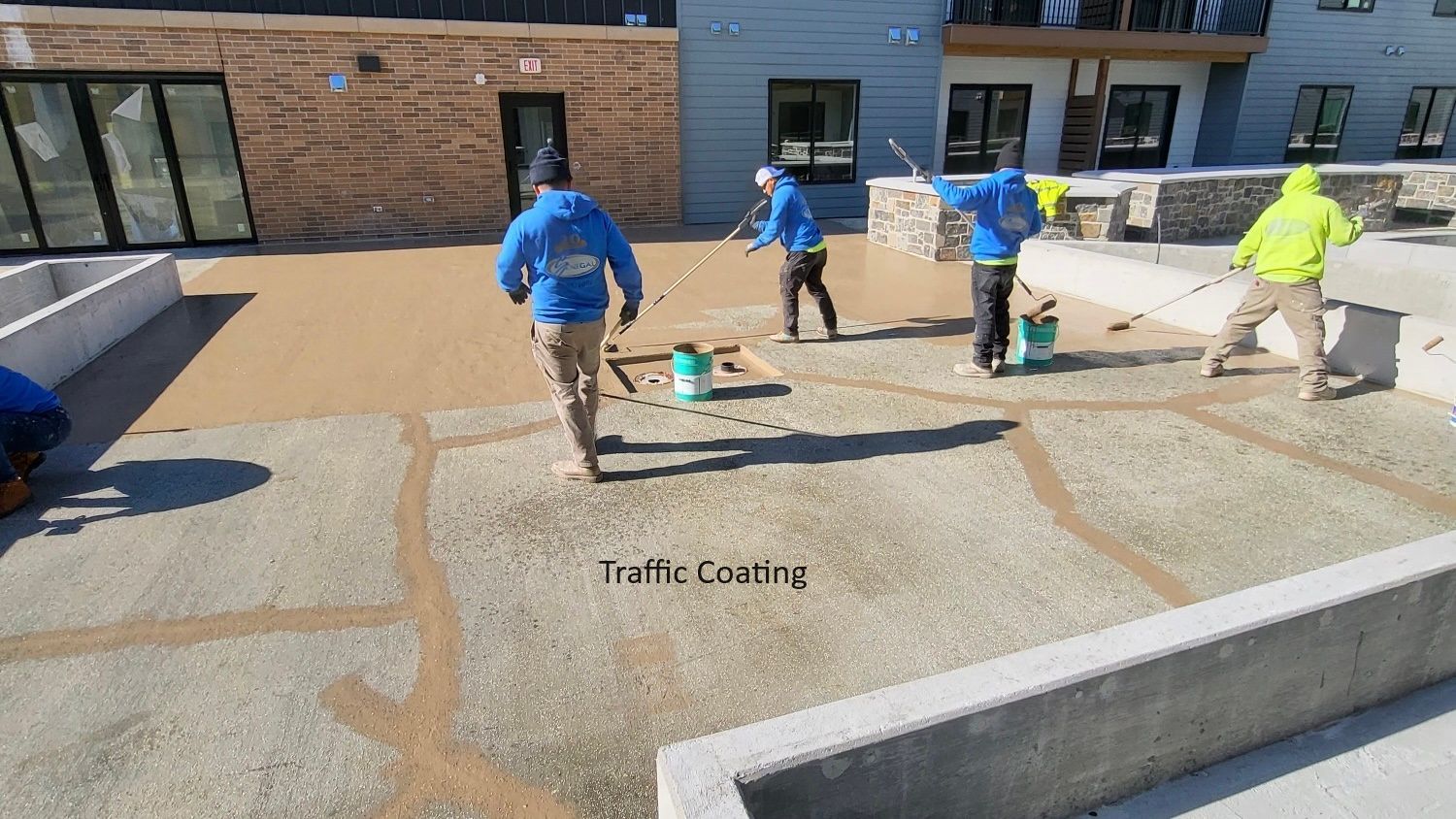 a group of people are working on a concrete surface .