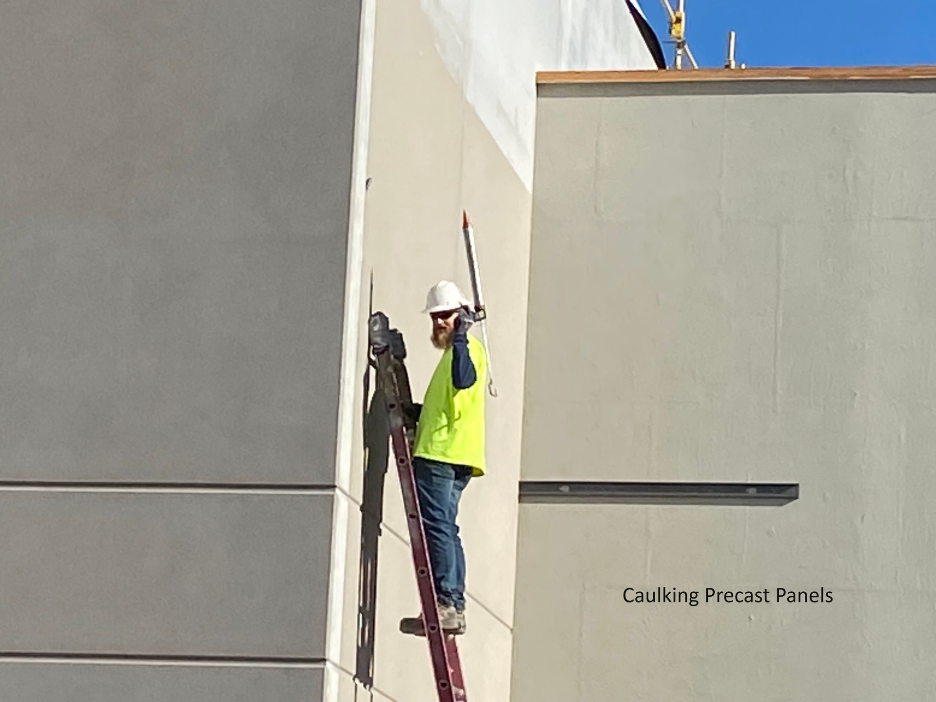 a man is standing on a ladder on the side of a building .