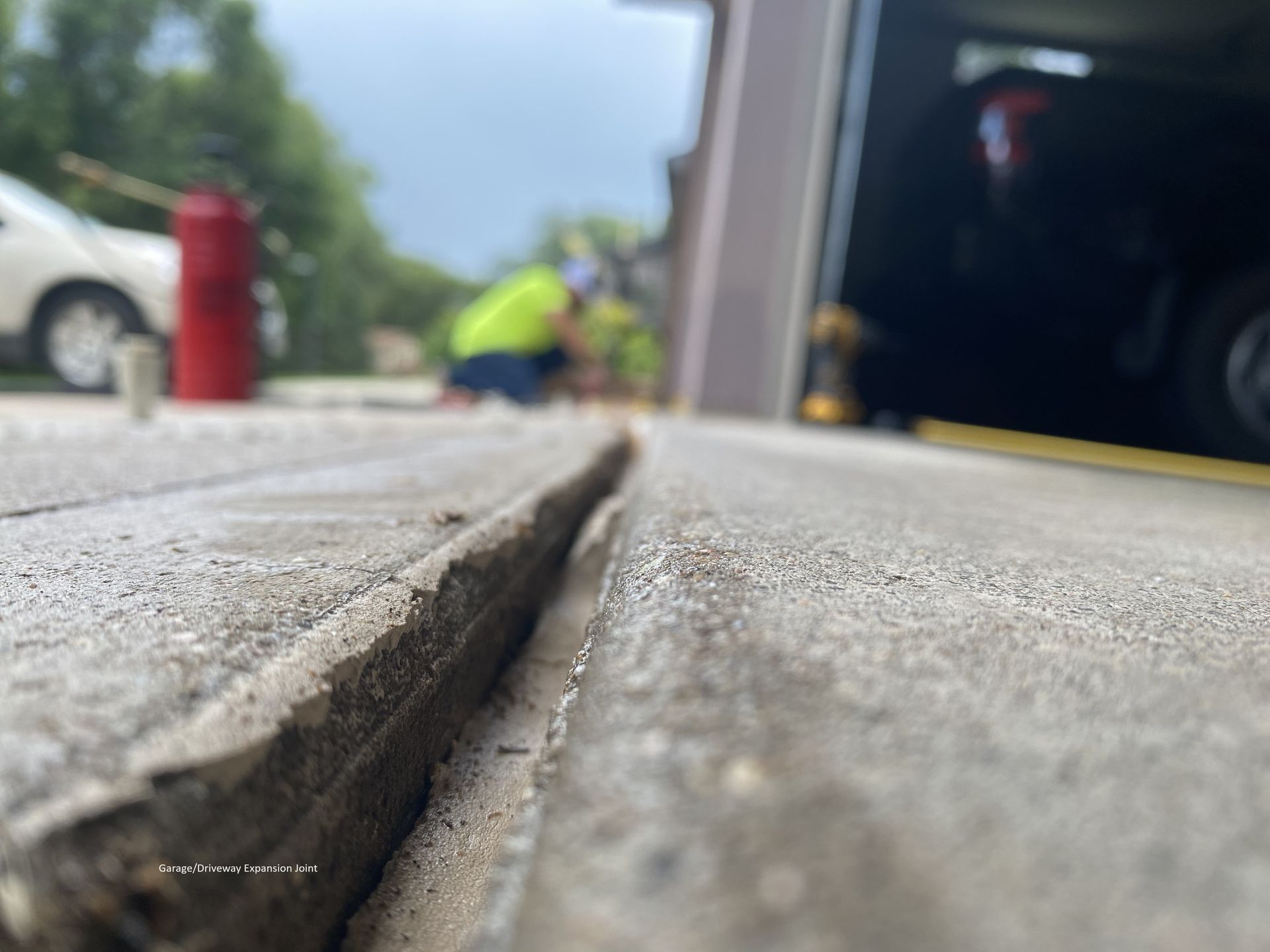 a close up of a concrete surface with a fire extinguisher in the background