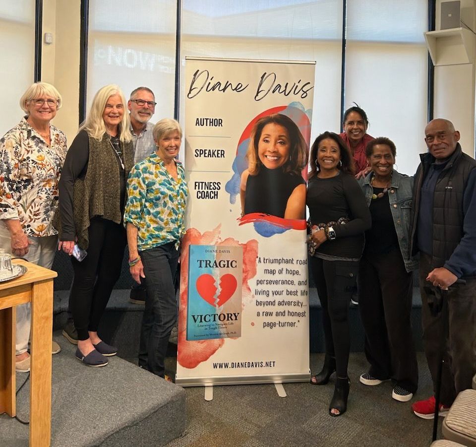 from a book signing A group of people standing around a sign that says Diane Davis author, speaker, fitness coach