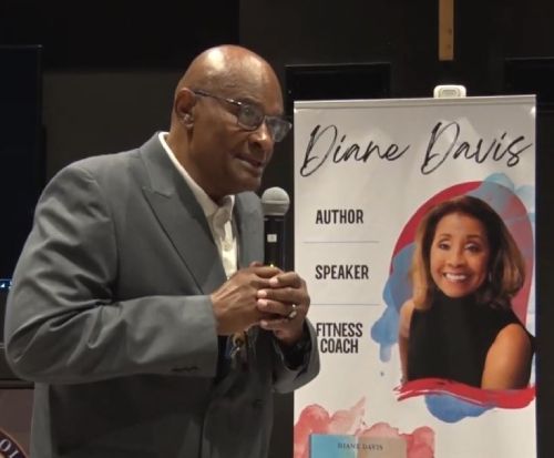 Ron Davis former NFL player stands in front of a sign that says Diane Davis