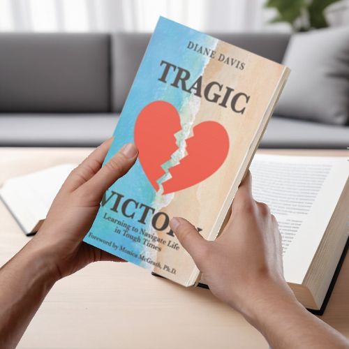 A person is holding a book titled tragic victor