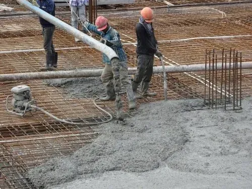 A Group Of Workers Are Pouring Concrete On A Construction Site — Doug's Concrete Pumping Pty Ltd in Glenella, QLD