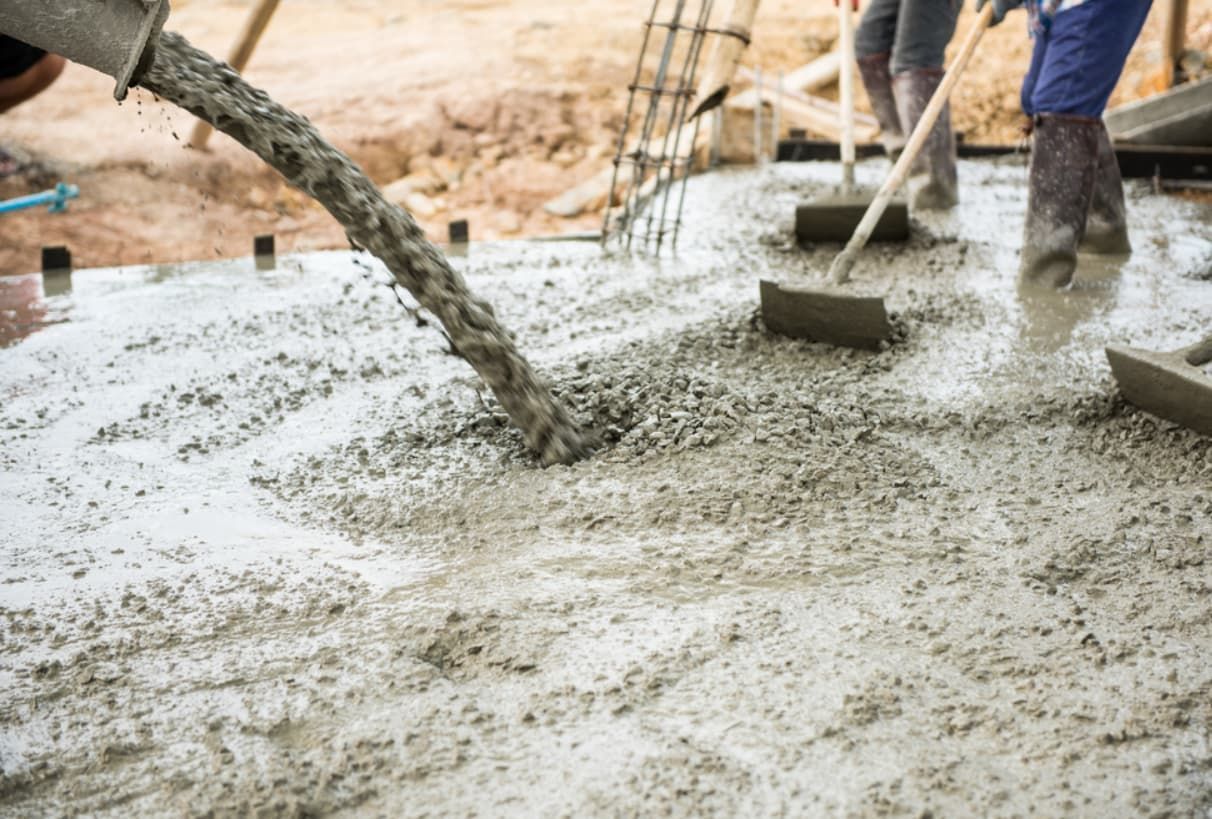 A Group Of People Are Pouring Concrete On A Construction Site — Doug's Concrete Pumping Pty Ltd in Glenella, QLD