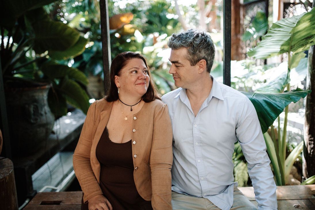 A man and a woman are sitting next to each other and smiling