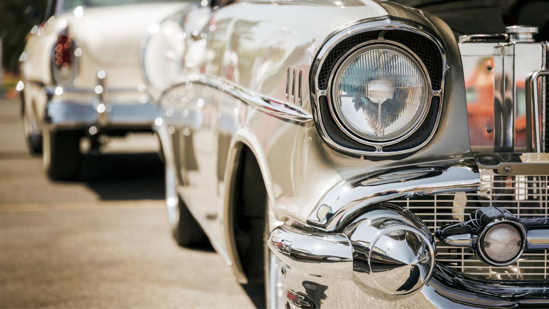 Classic silver car with chrome detailing, parked outdoors.