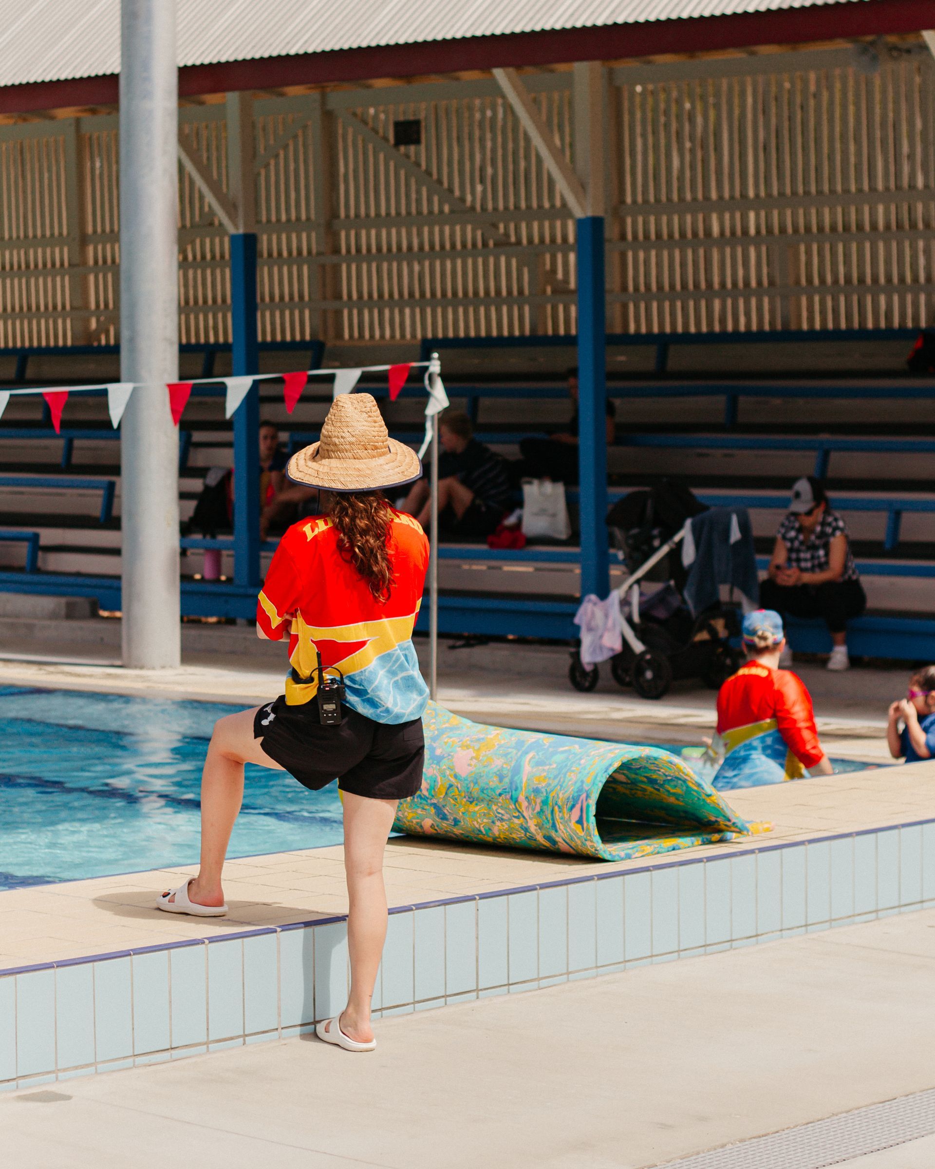 A Woman In A Straw Hat Is Standing Next To A Swimming Pool — Splash-A-Bout Swim School Pty Ltd In Park Avenue, QLD