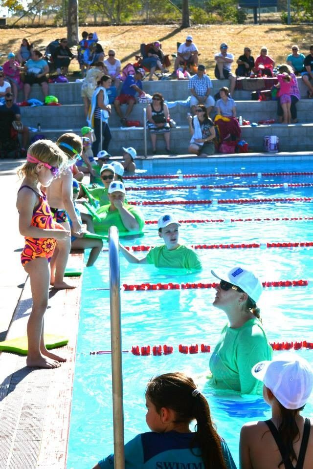 A Group Of People Are Standing Around A Swimming Pool — Splash-A-Bout Swim School Pty Ltd In Rockhampton Northside, QLD