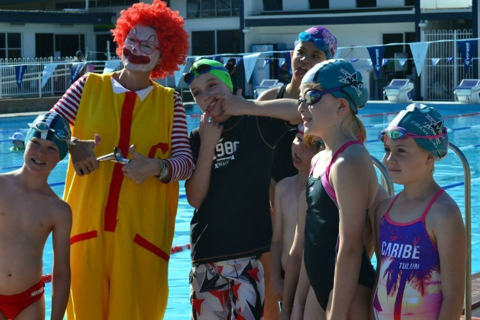 Children Are Standing Around A Pool With A Clown — Splash-A-Bout Swim School Pty Ltd In Park Avenue, QLD