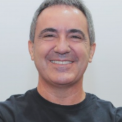 Um homem vestindo uma camisa preta está sorrindo para a câmera