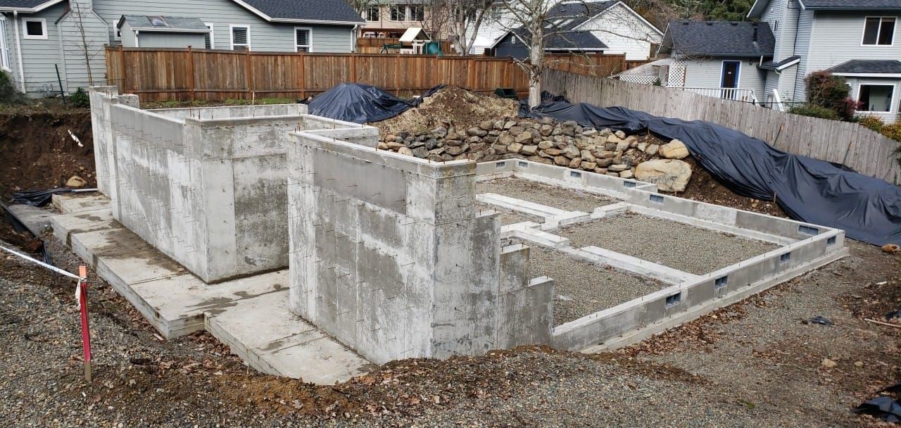 a large pile of rocks sits in front of a house under construction