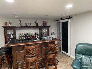 A living room with a bar and a sliding barn door