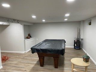 There is a pool table in the middle of the room.