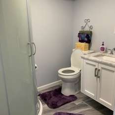 A bathroom with a toilet , sink , and shower stall.