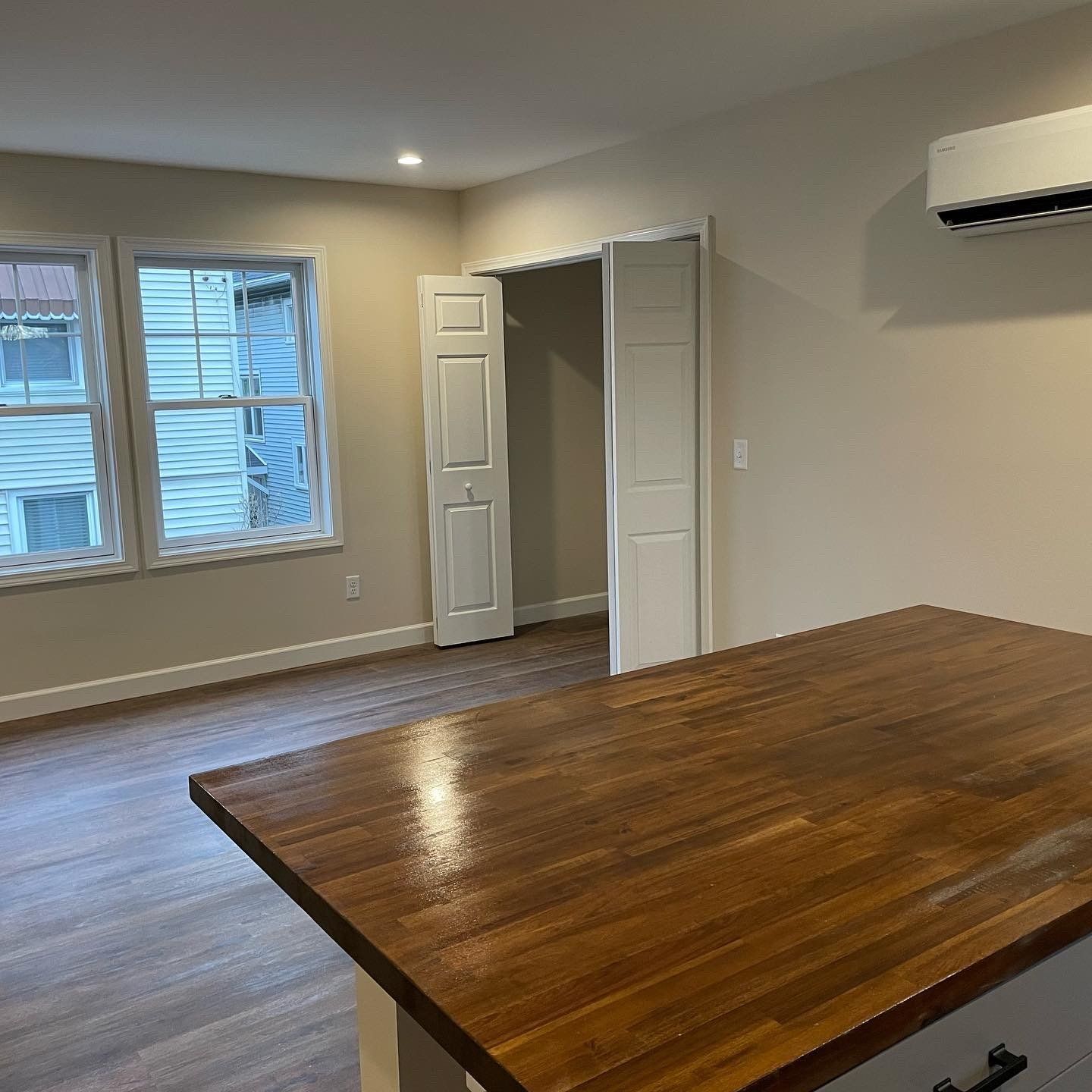 A kitchen with a wooden counter top and a wooden floor.