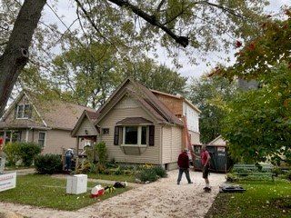 A group of people are working on a house.