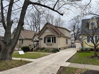 A small house with a brown roof is sitting next to a yellow house.