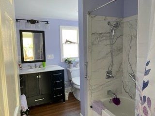 A bathroom with a sink , toilet , shower and bathtub.