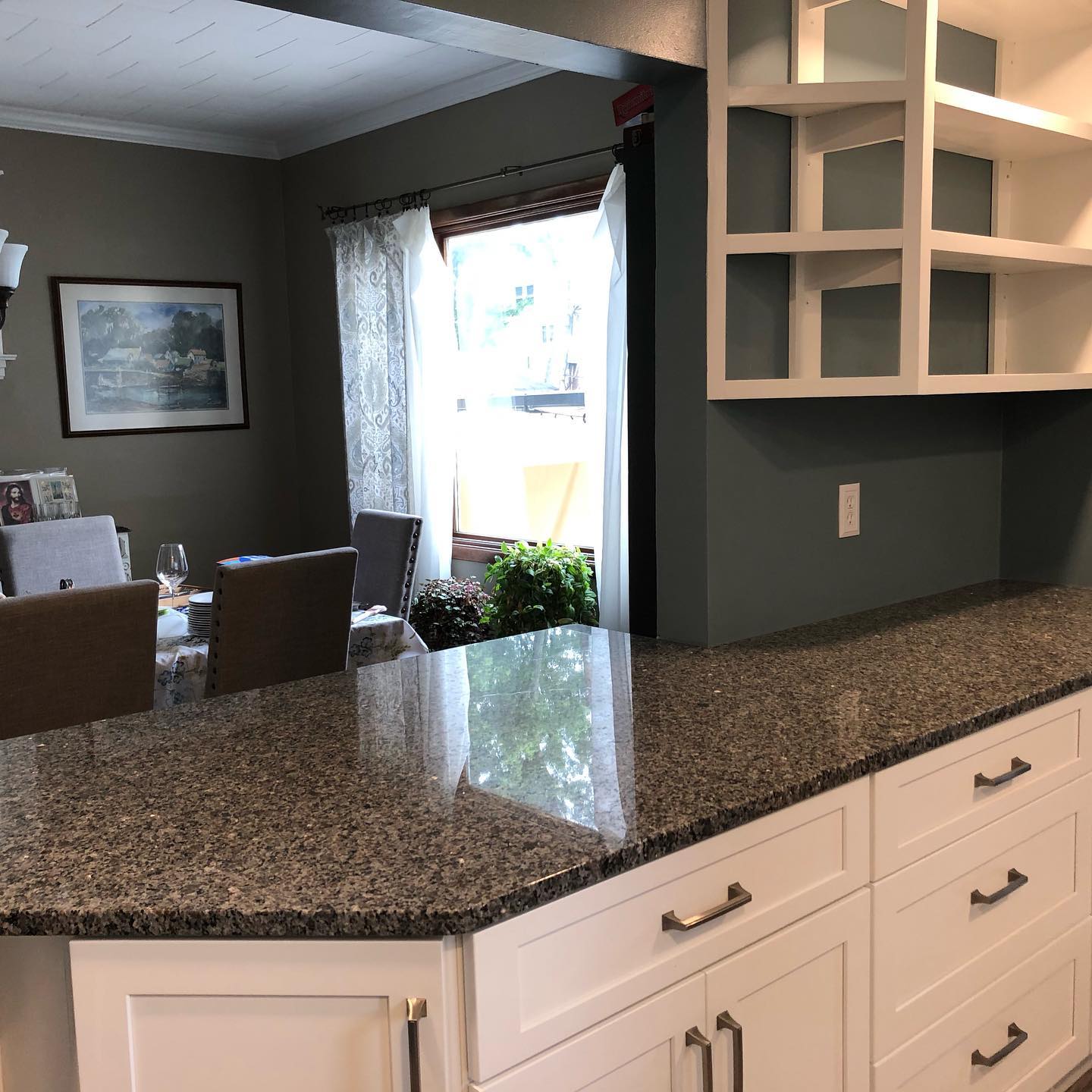 A kitchen with granite counter tops and white cabinets