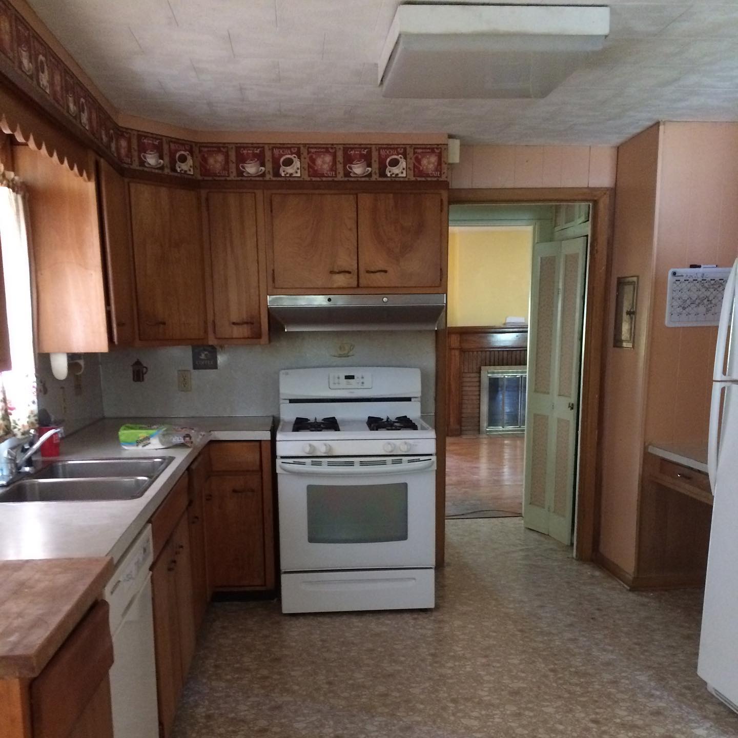 A kitchen with wooden cabinets and a white stove