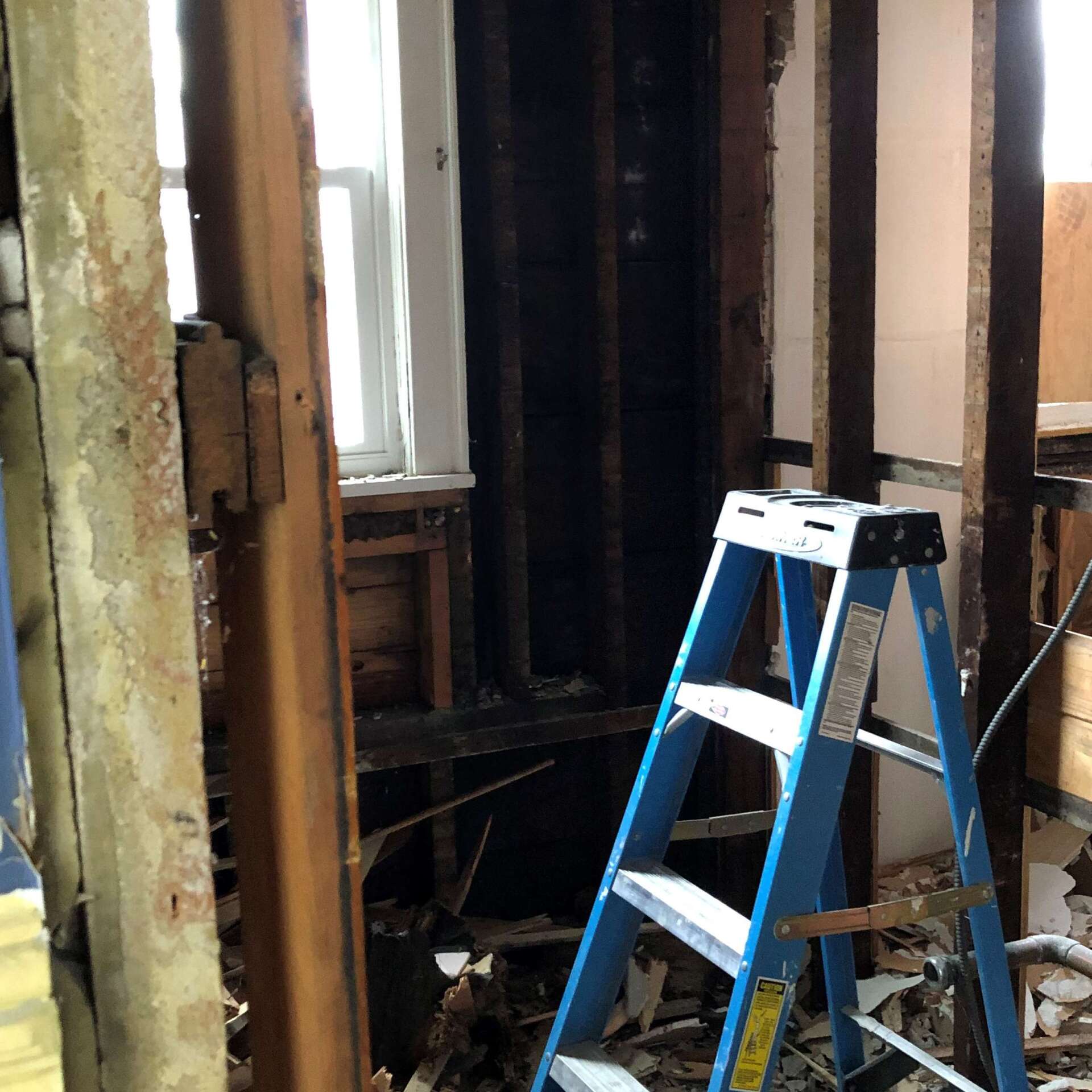 A blue ladder is sitting in the middle of a room