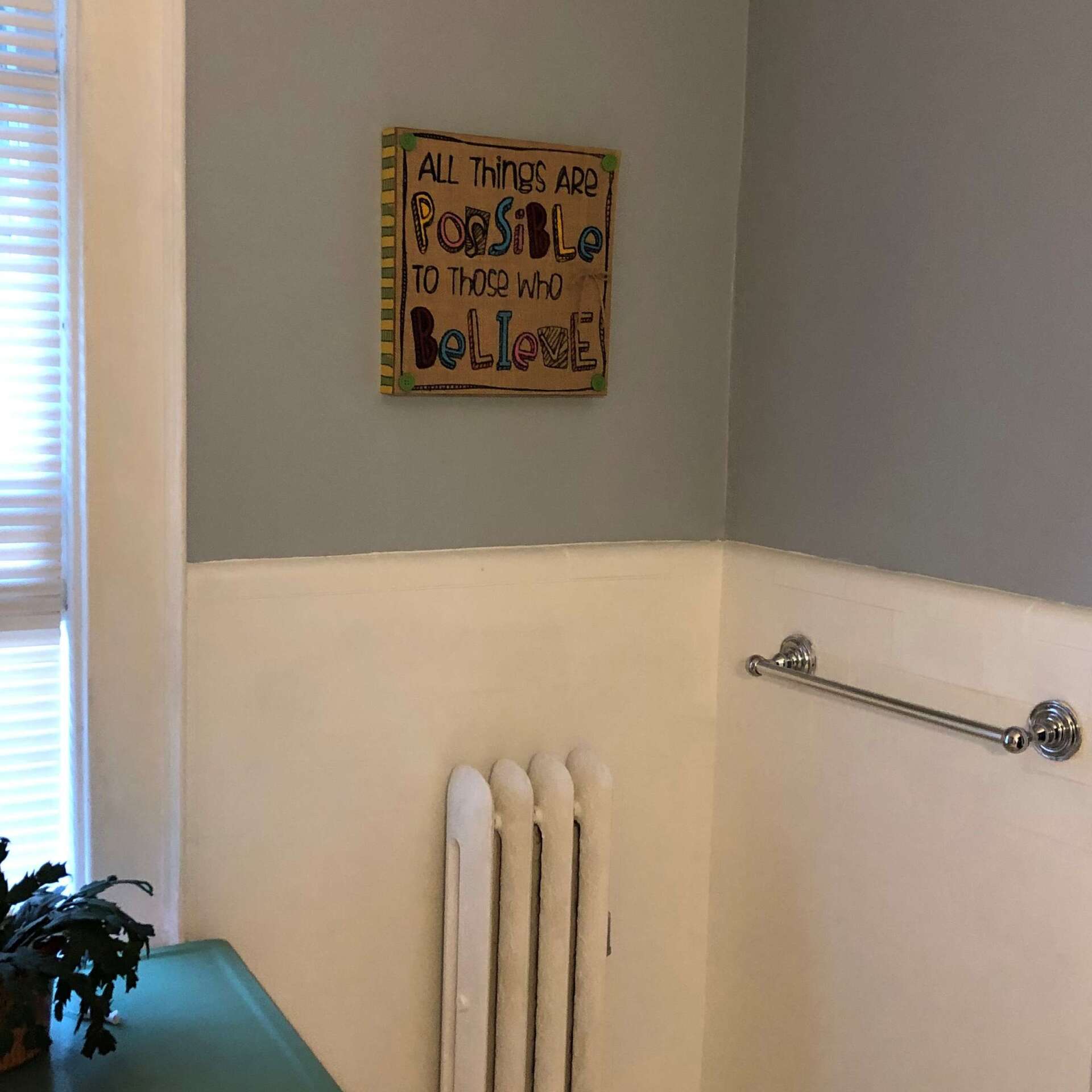 A bathroom with a sign that says all things are possible to those who believe