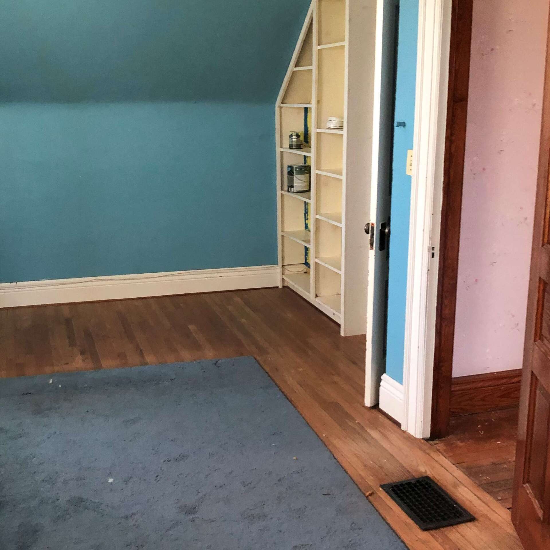 A room with a blue wall and a white shelf