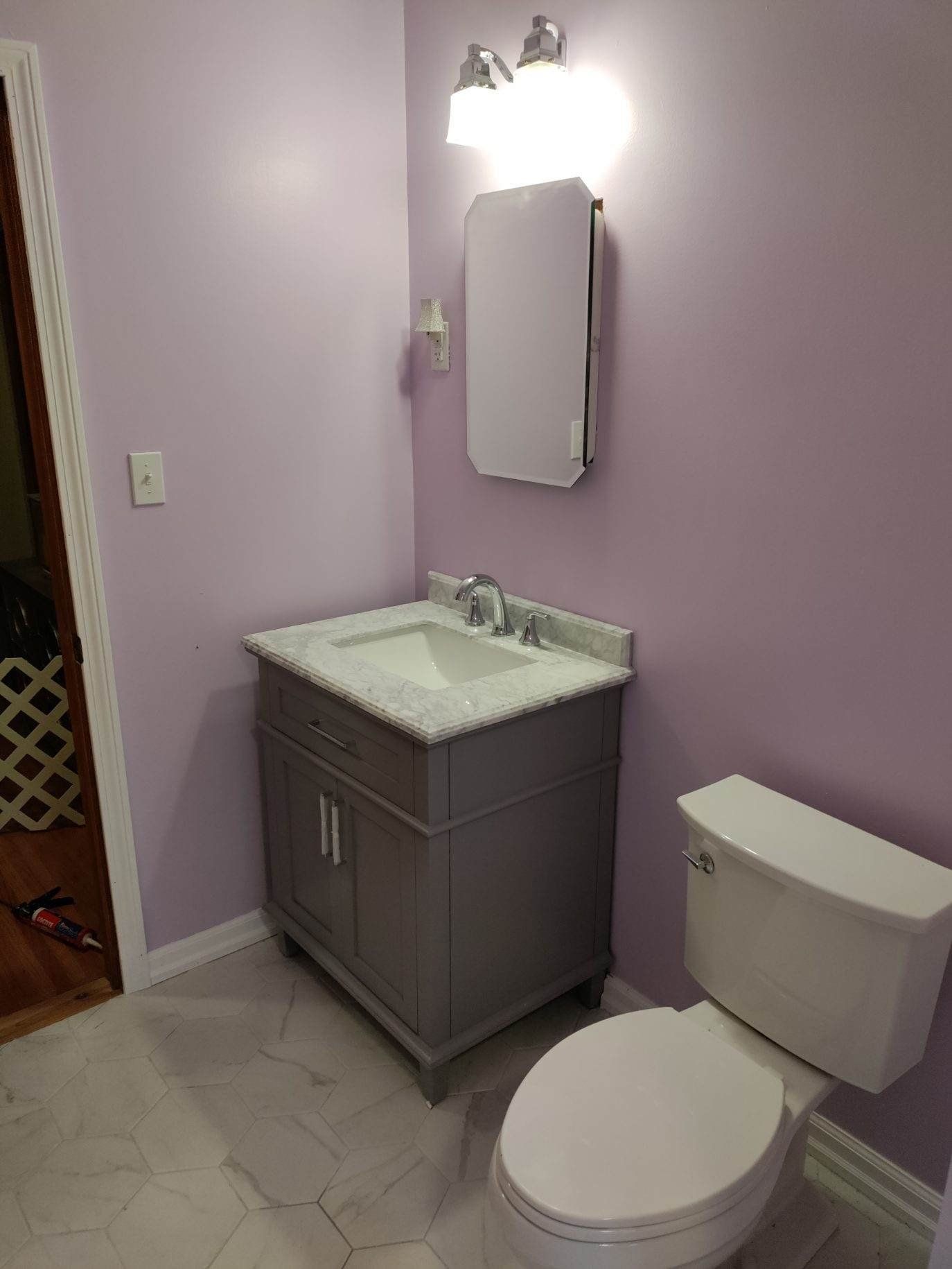 A bathroom with a sink , toilet and mirror.