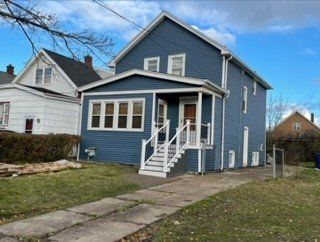 A blue house with a white porch and stairs