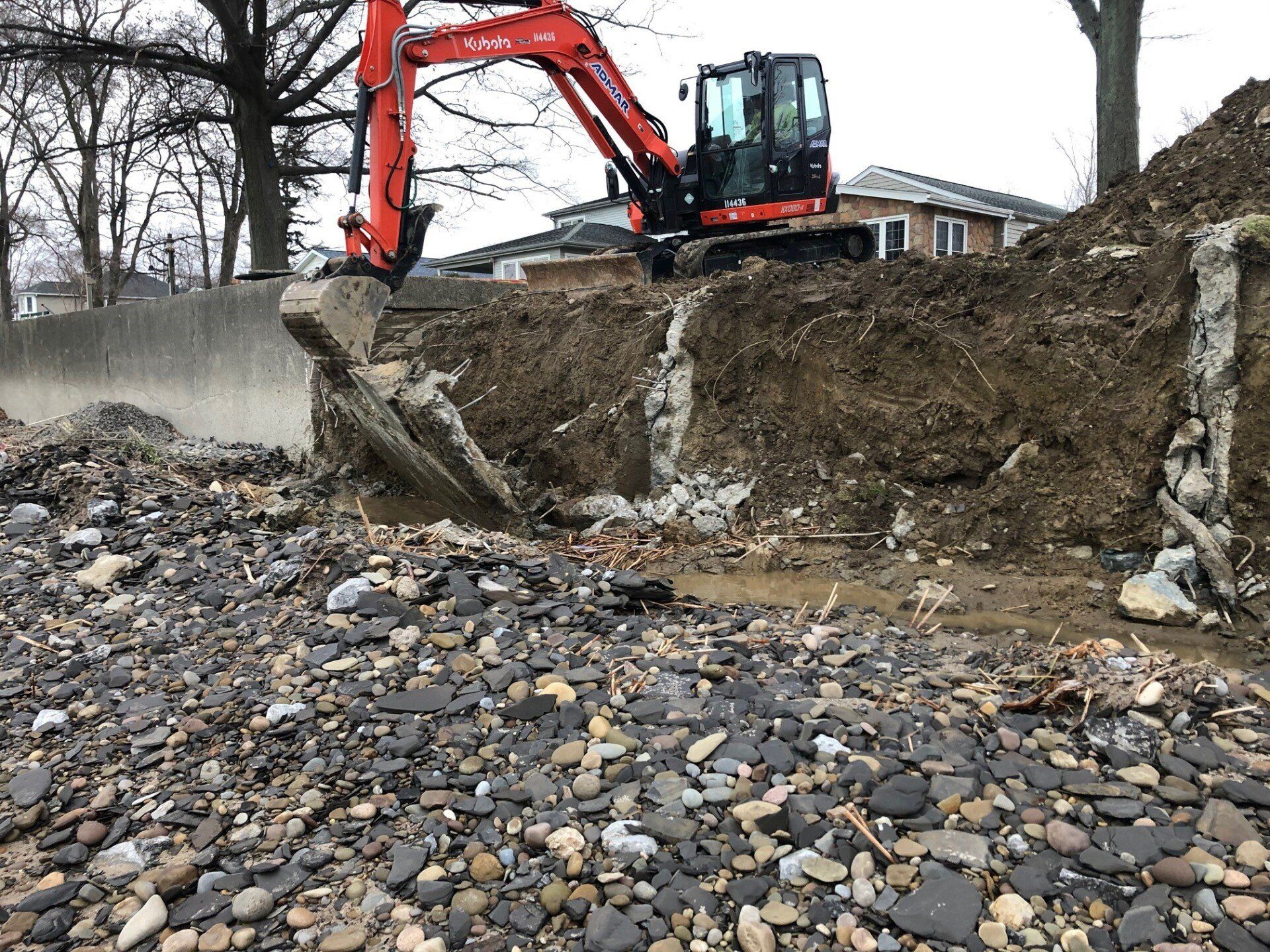 An excavator is digging a hole in a pile of rocks.