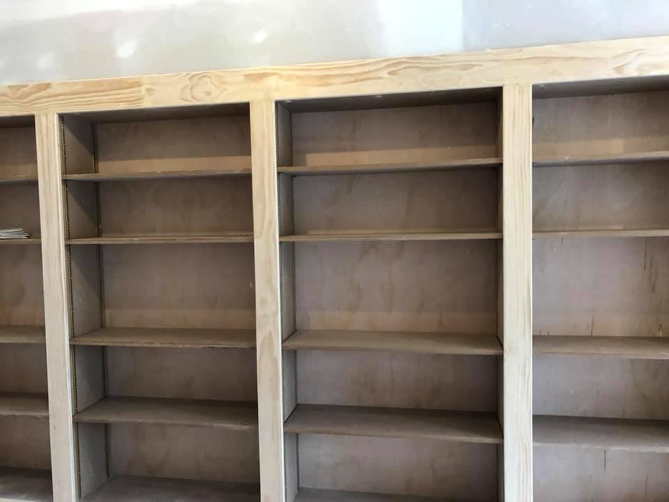 A row of empty wooden shelves in a room.