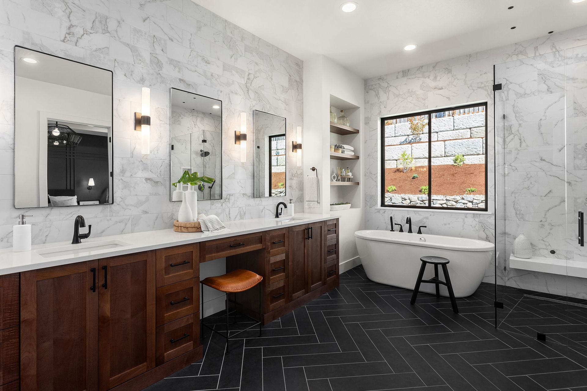 A bathroom with a tub , sinks , mirrors and a window.