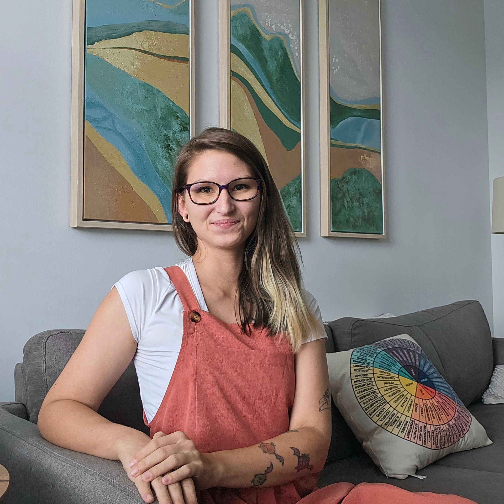 A woman with brown hair and glasses smiling and facing the camera.