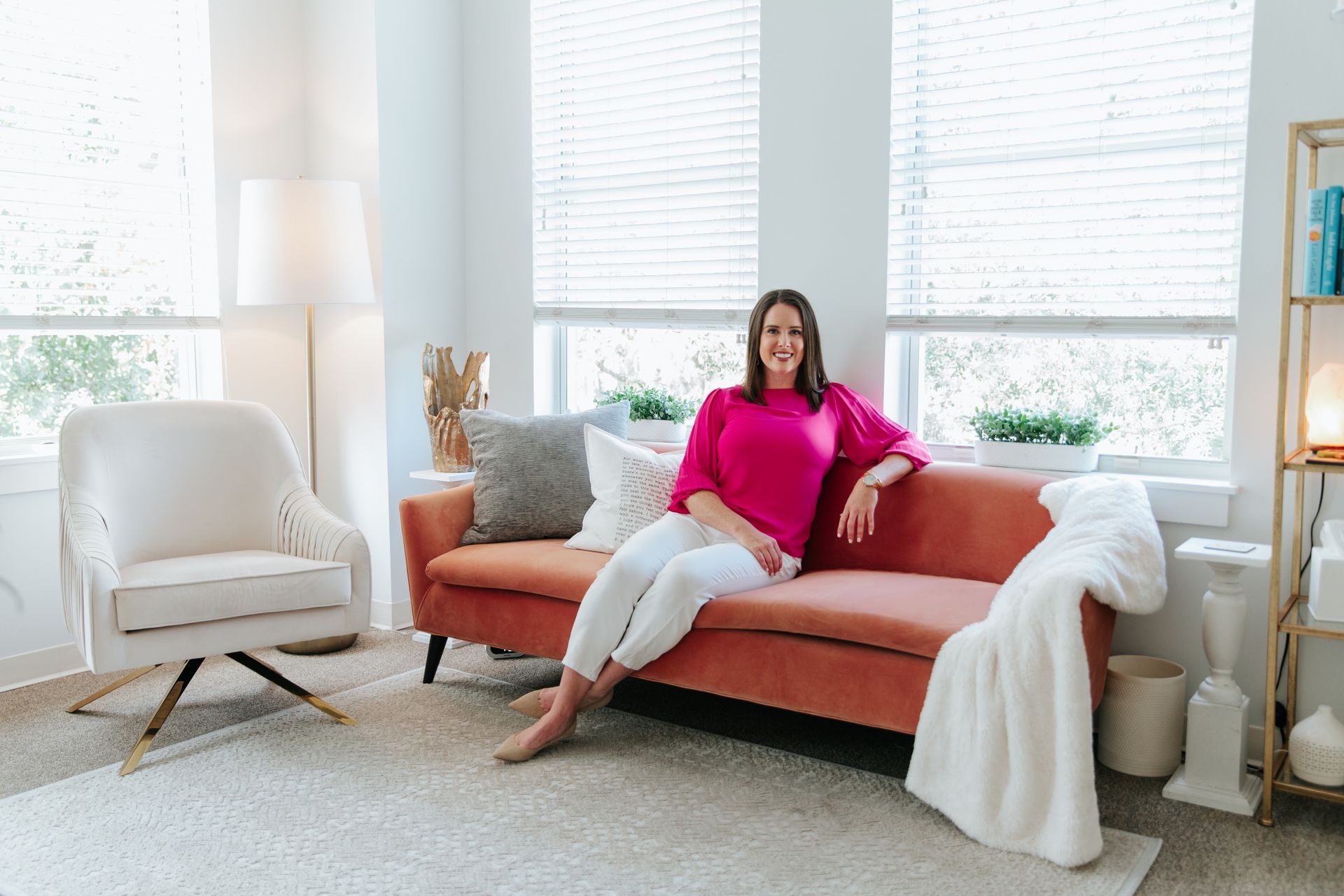 A woman is sitting on a couch in a living room.
