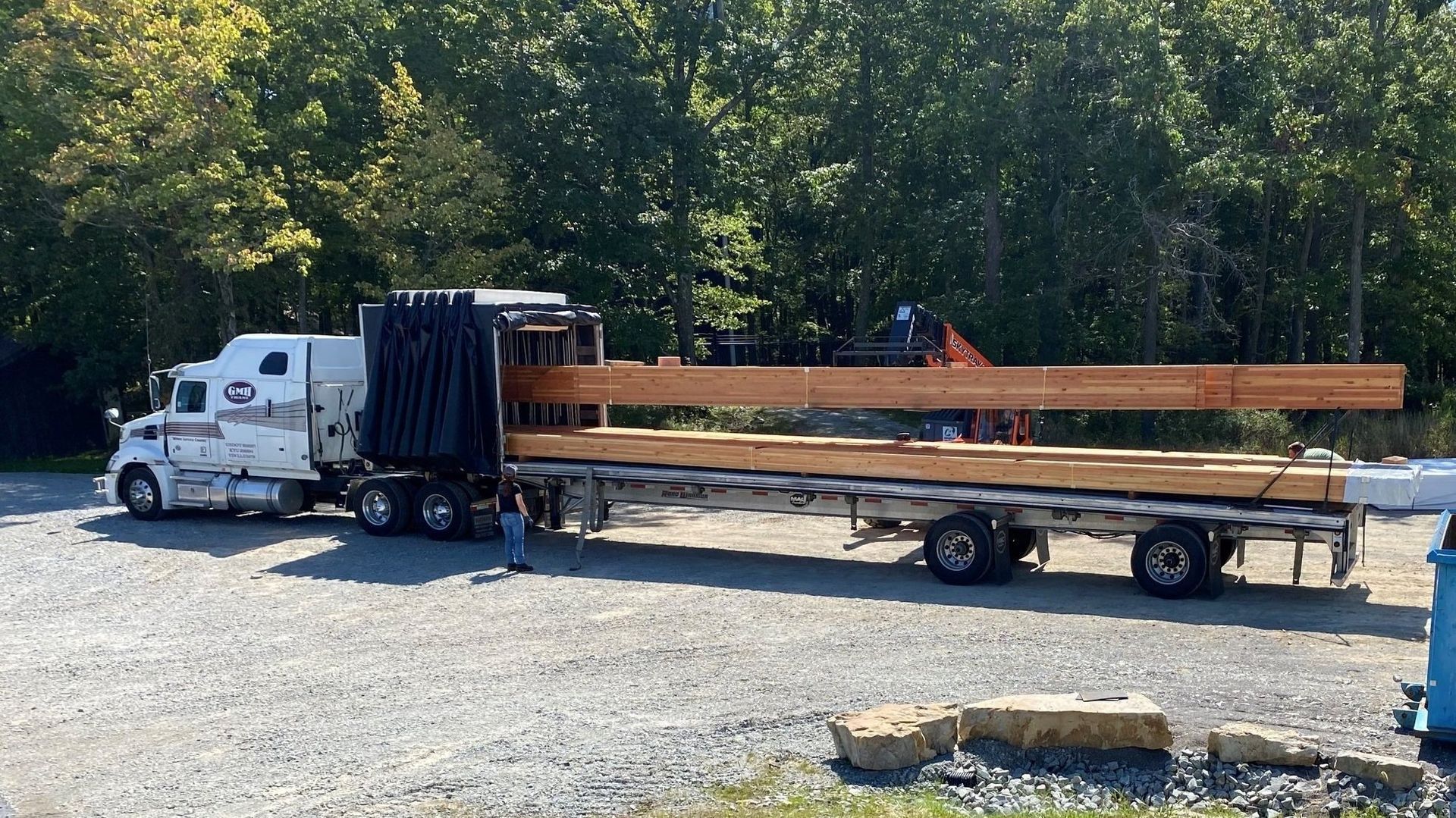 A semi truck is carrying a large load of wood on a trailer.