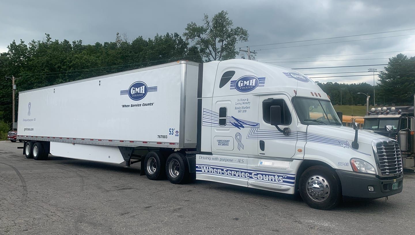 A white semi truck is parked in a parking lot.