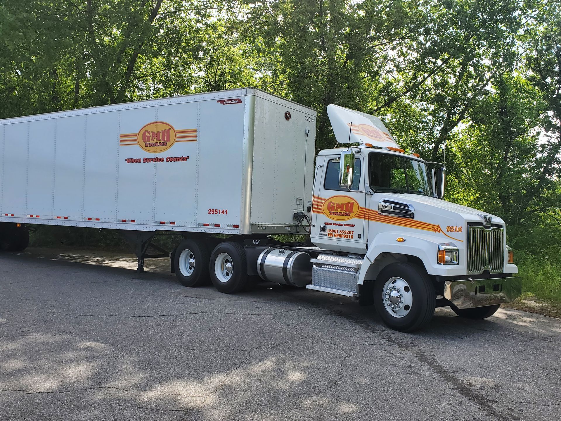 A white semi truck is parked on the side of the road.