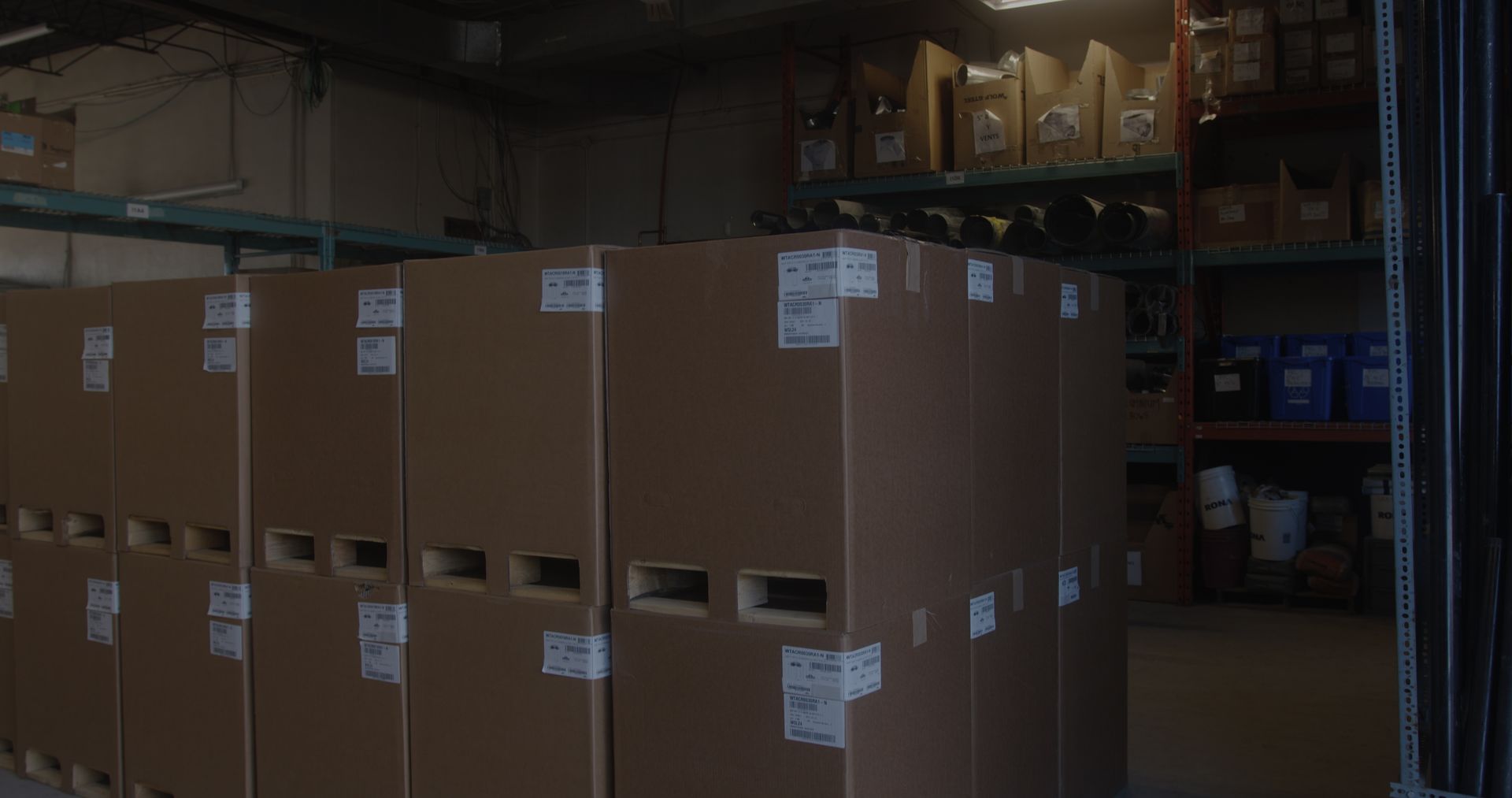 A warehouse filled with lots of cardboard boxes and shelves.